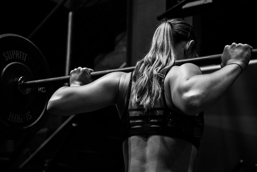 Photograph of a weightlifter with a barbell on her shoulders