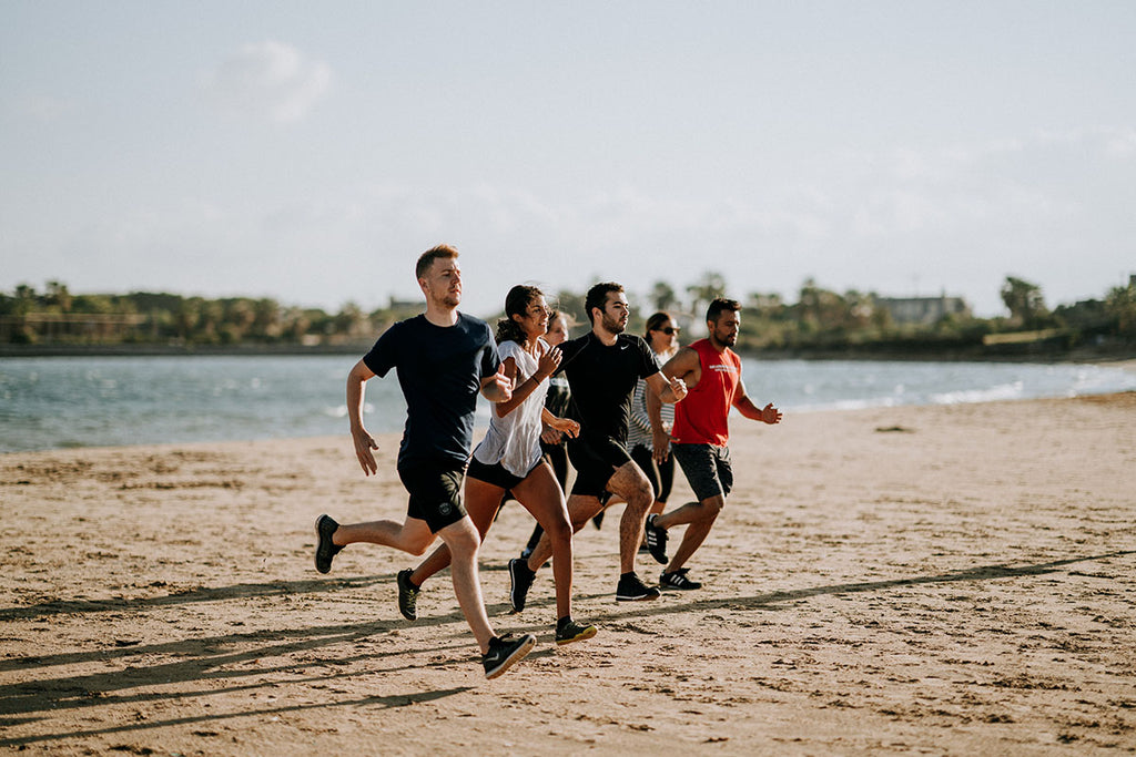 Photograph of 6 runners running on the beach