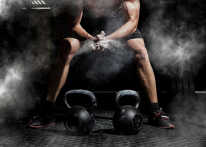 Photograph of a weightlifter applying chalk